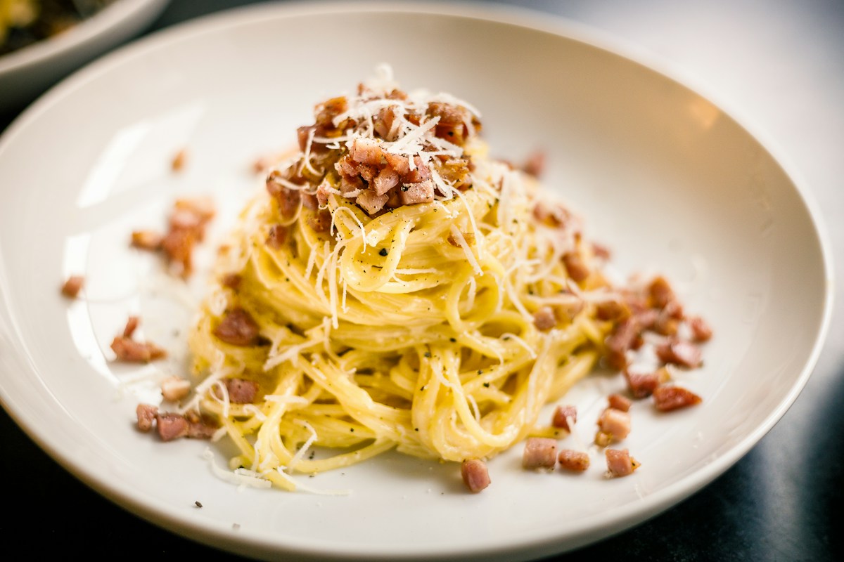 Un piatto di spaghetti alla carbonara con guanciale e formaggio
