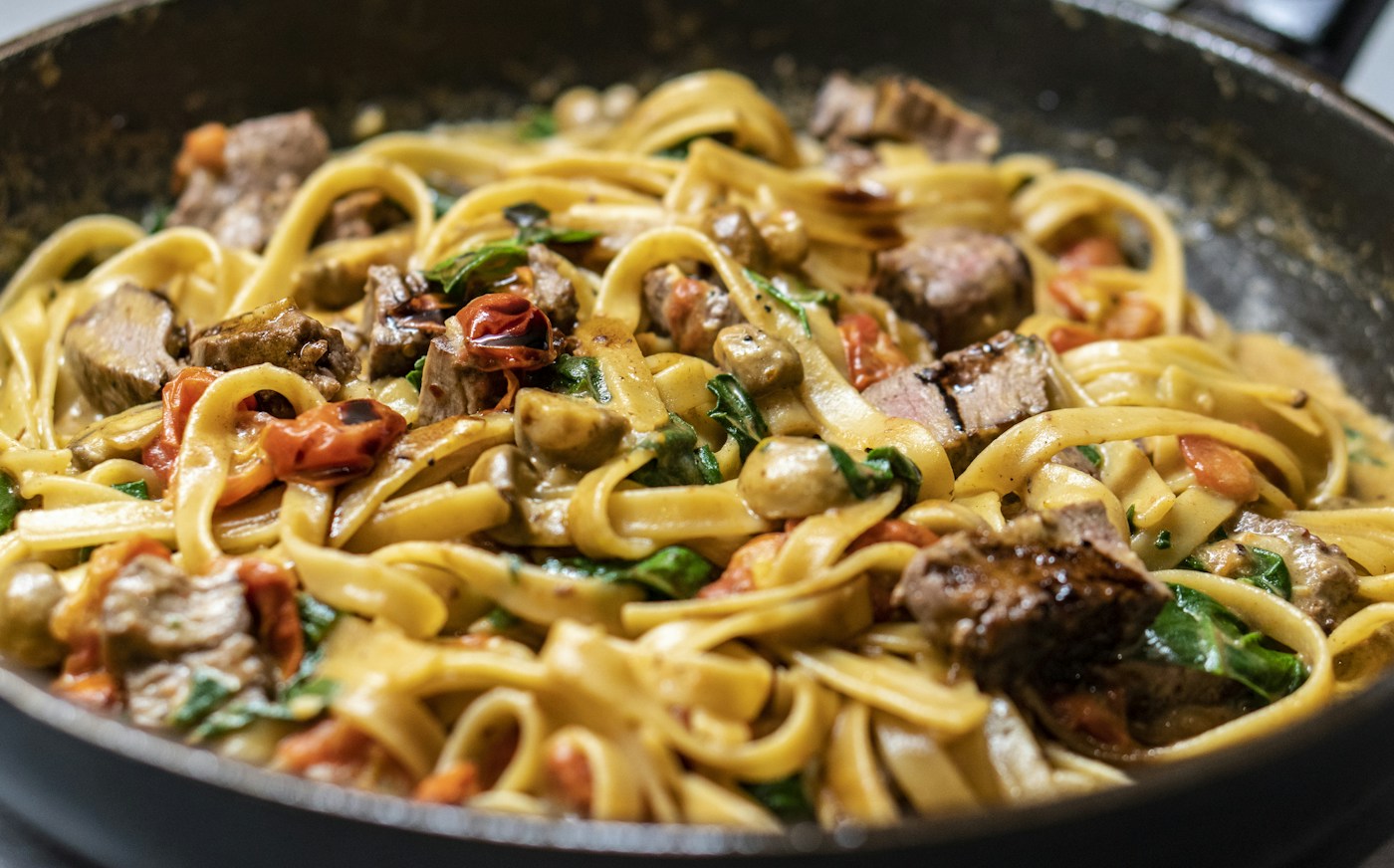 Tagliatelle con funghi e pomodorini in padella